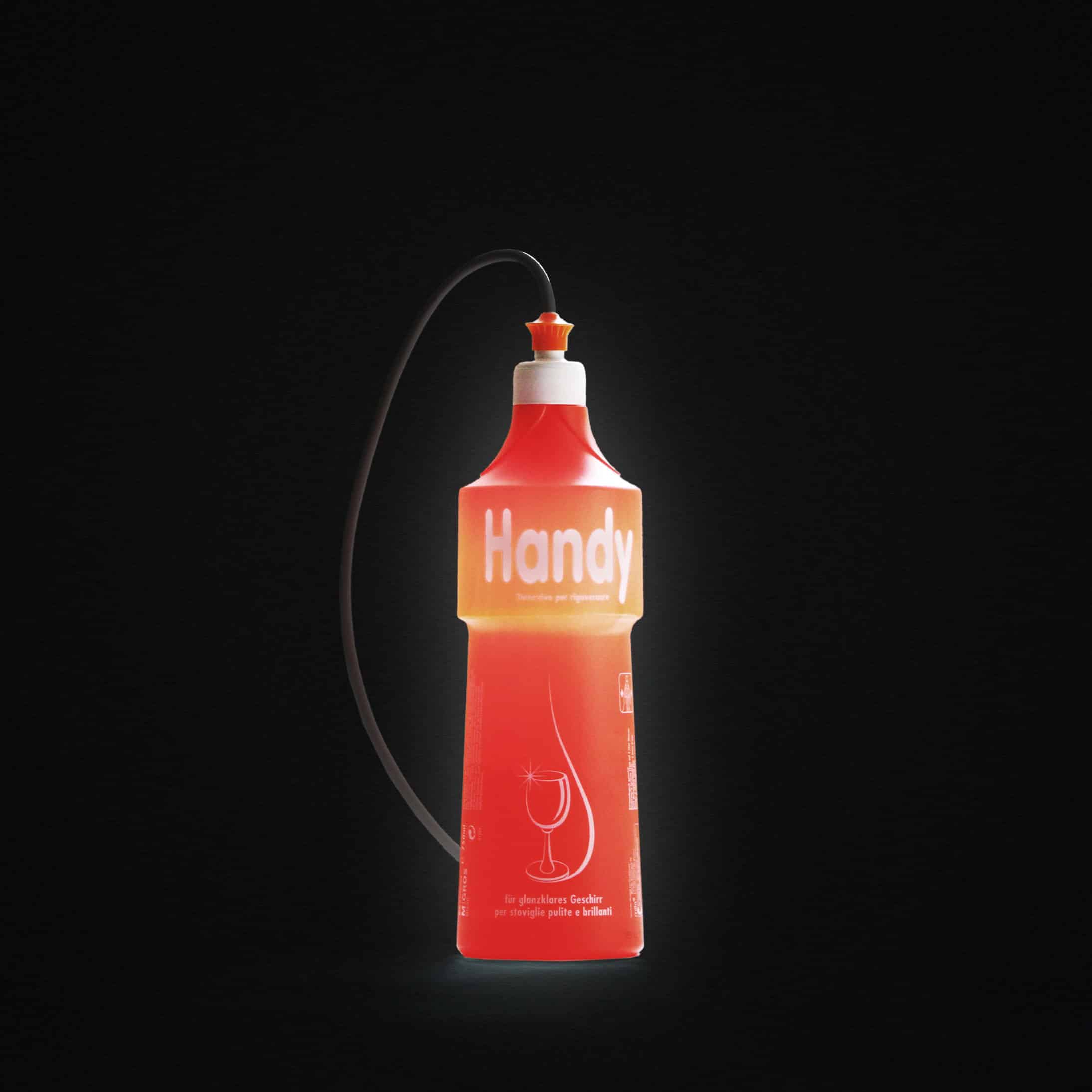 Rote Flasche mit der Aufschrift "Handy" und einem Draht, der oben angebracht ist, auf schwarzem Hintergrund.