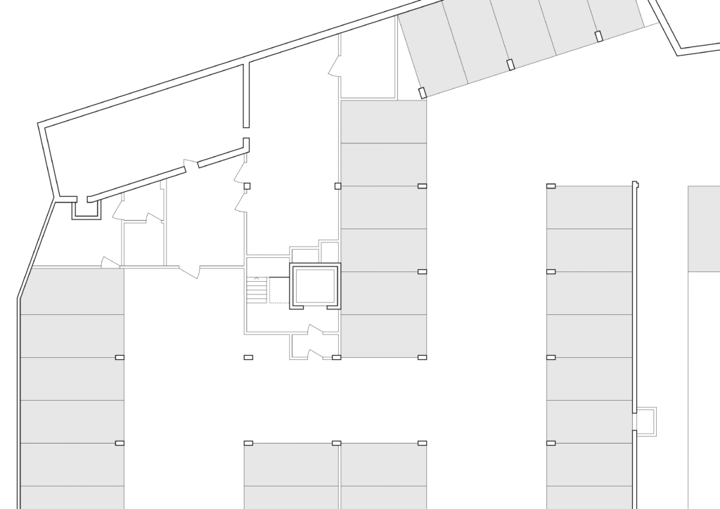 von KGRUPPE Architekten Basel - Grundriss eines Parkplatzes mit mehreren Parkbuchten und Treppenhaus.